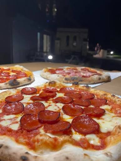 Fresh pepperoni pizzas from the wood-fired oven